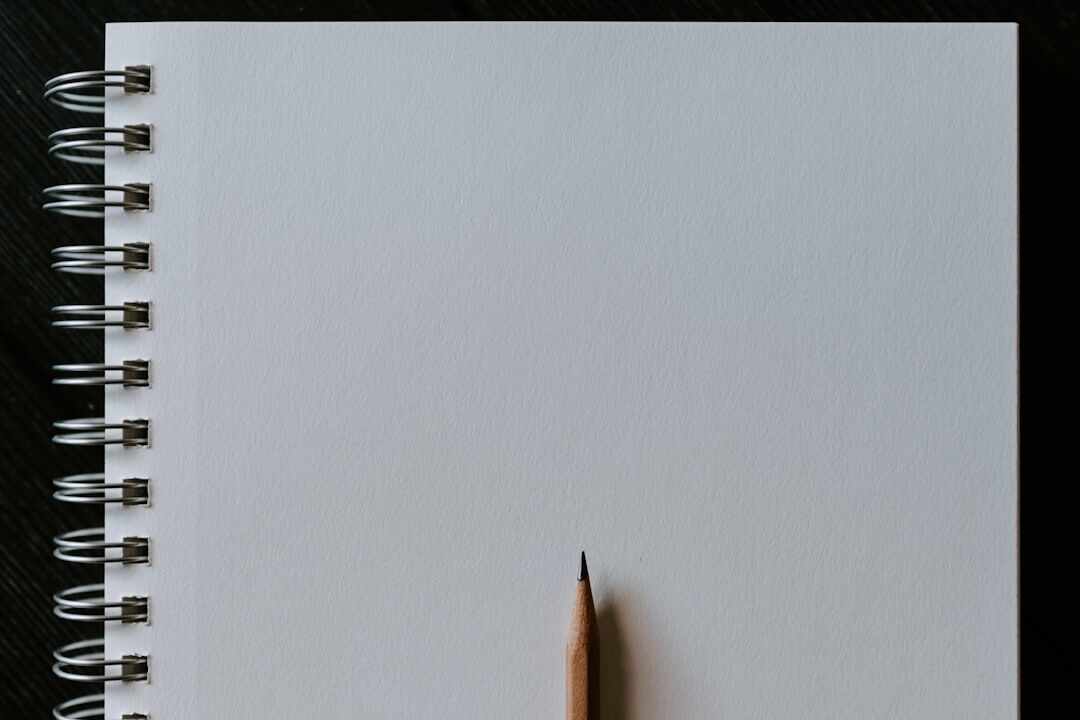 Close-up of a notebook, fountain pen, coffee cup and magnifying glass on a wooden desk