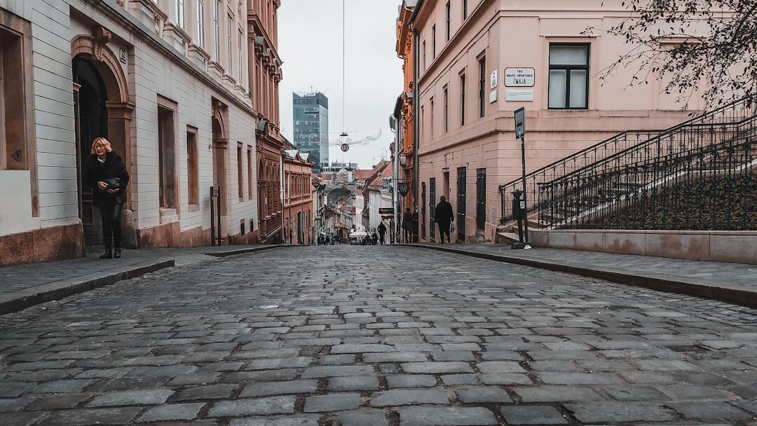 Foggy cobblestone street in old Zagreb at night lit by a single lantern